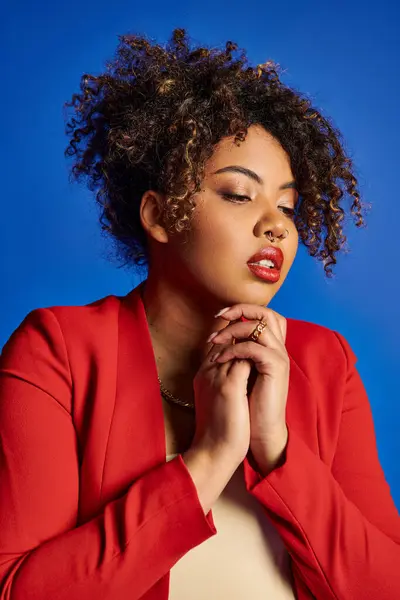 Bella elegante modello afro-americano femminile in abito vibrante guardando lontano sullo sfondo blu — Foto stock