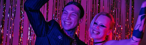 Un hombre y una mujer de pie lado a lado en una animada fiesta de rave o club nocturno de rave - foto de stock