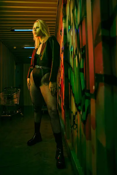 Женщина, стоящая рядом с яркой разноцветной стеной — стоковое фото
