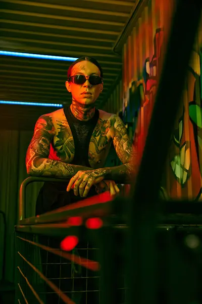 Hombre con tatuajes sentado en silla - foto de stock