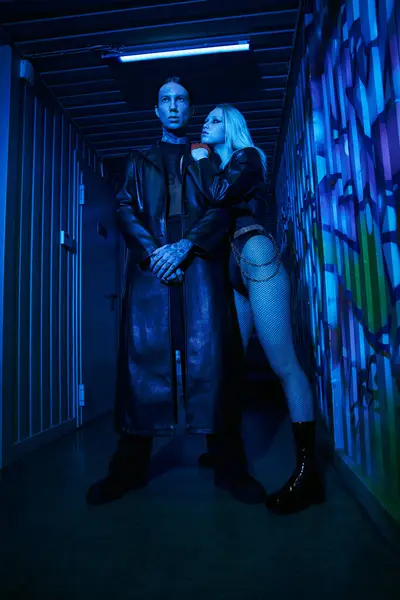 Un hombre y una mujer están de pie en un pasillo, posiblemente en una fiesta de rave o discoteca - foto de stock