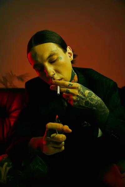 Un homme assis sur un canapé, fumant une cigarette — Photo de stock
