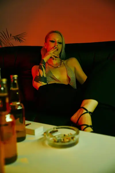 Eine Frau sitzt auf einem Sofa und hält einen Teller mit Essen in der Hand — Stockfoto