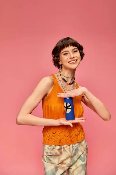 Joyful young woman with short brunette hair posing with refreshing soda can on pink, summer drink — Stock Photo