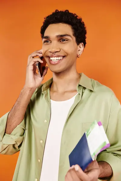 Handsome jolly african american man talking by phone and holding passport and ticket in hand — Stock Photo
