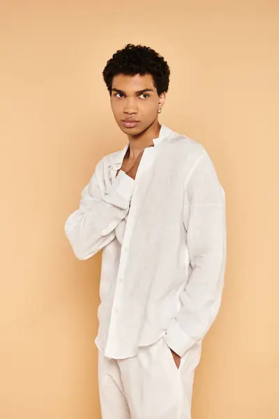 Polido homem americano africano chique em roupas brancas elegantes olhando para longe no pano de fundo bege — Fotografia de Stock