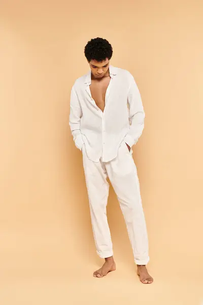 Elegant chic african american man in elegant white clothing looking away on beige backdrop — Stock Photo