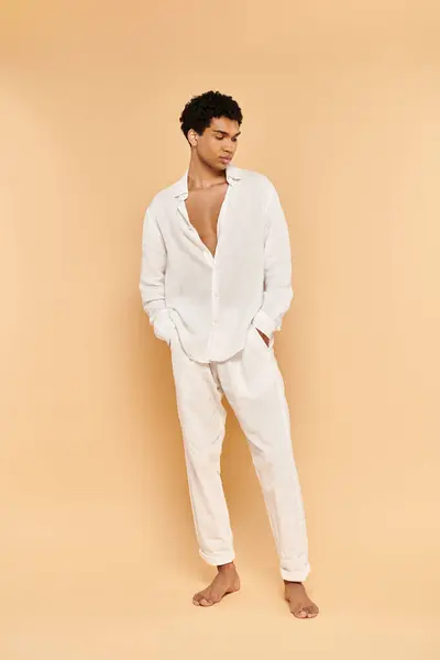 Homem americano africano chique de bom gosto em roupas brancas elegantes olhando para longe no pano de fundo bege — Fotografia de Stock