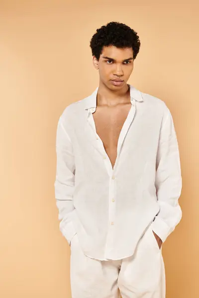 Bem vestido homem americano africano chique em roupas brancas elegantes olhando para o fundo bege — Fotografia de Stock