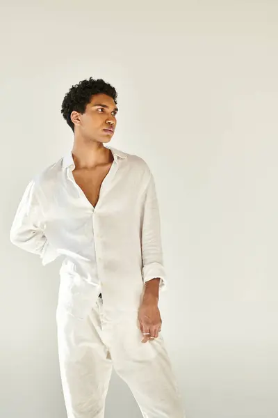 Alluring elegant african american man in chic linen clothing looking away on beige backdrop — Stock Photo