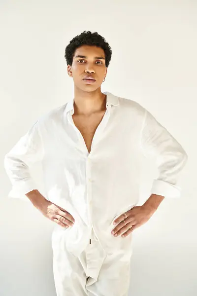 Fashionable young african american man in white attire and looking at camera on beige backdrop — Stock Photo