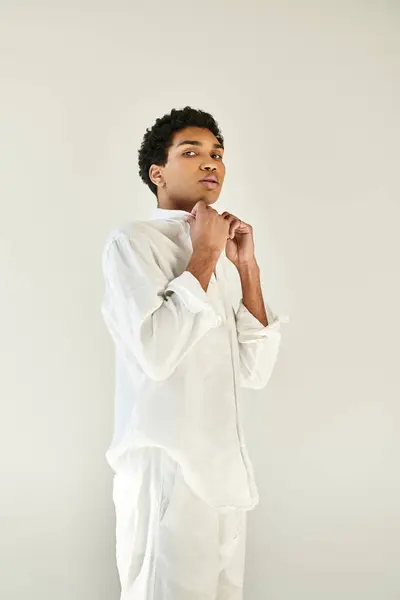 Elegante attraente uomo africano americano in abito accogliente in posa su sfondo beige e guardando la fotocamera — Foto stock