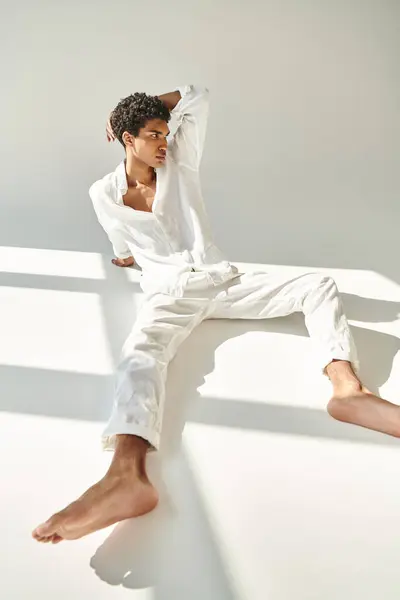 Attraente modello afroamericano maschio in lino sofisticato abbigliamento in posa su sfondo beige — Foto stock