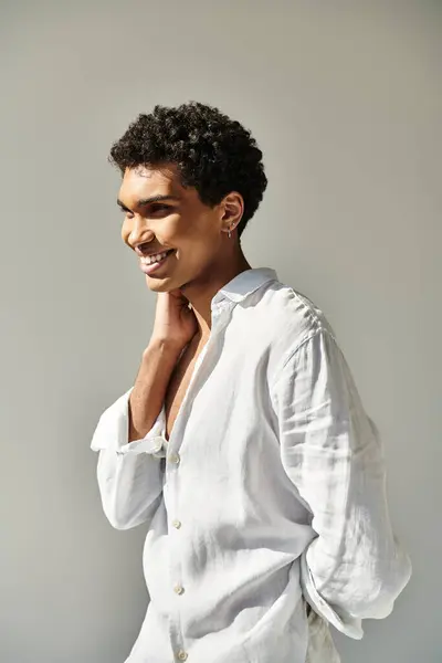 Cheerful alluring african american male model in white linen attire looking away on beige backdrop — Stock Photo