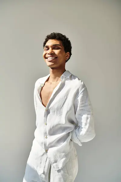 Alegre guapo africano americano hombre en ropa de lino sonriendo a la cámara sobre fondo beige - foto de stock