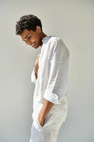 Gioioso seducente afro-americano modello maschile in lino bianco abbigliamento guardando lontano su sfondo beige — Foto stock