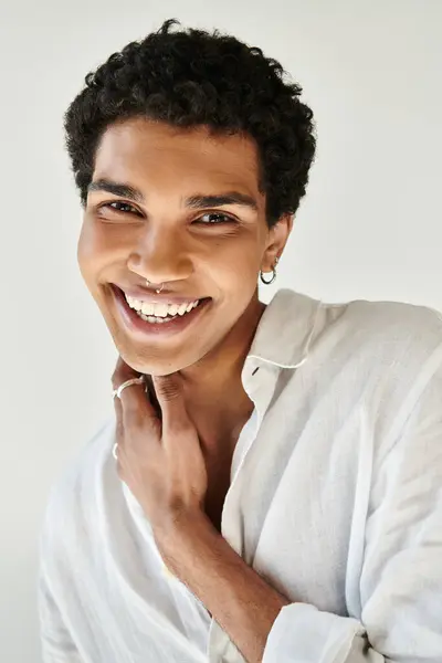 Alegre hombre afroamericano de moda en ropa de lino sonriendo a la cámara sobre fondo beige - foto de stock