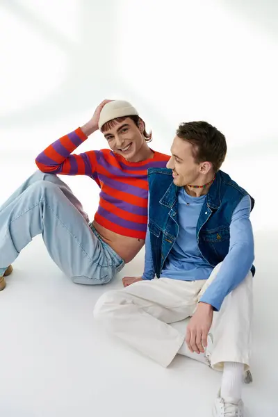 Two joyous trendy lgbtq friends in vivid stylish clothes posing together on gray background — Stock Photo