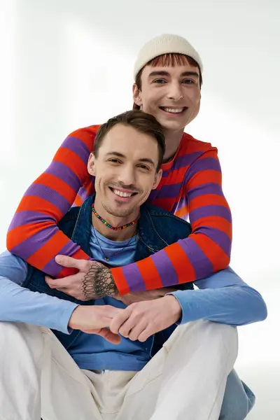 Two happy good looking lgbt friends in vibrant attires looking at camera posing on gray backdrop — Stock Photo