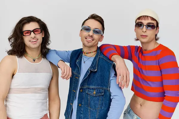 Three trendy appealing gay friends in vibrant trendy attires with chic sunglasses, pride month — Stock Photo