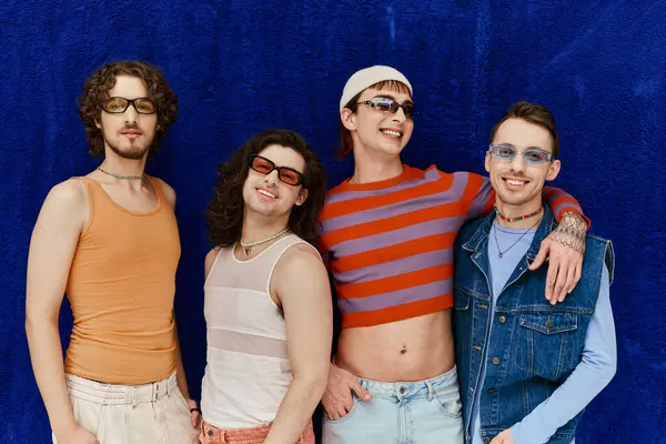 Modisch fröhlich attraktive schwule Männer mit Sonnenbrille in lebendigen Kleidern posieren auf blauem Hintergrund, Stolz — Stockfoto