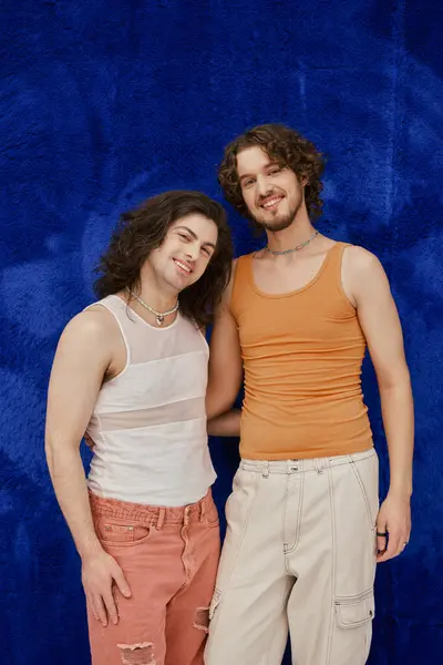 Cheerful attractive elegant gay friends in cozy outfits on dark blue backdrop, pride month — Stock Photo
