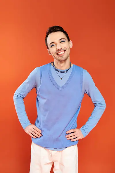 Mery attrayant élégant gay homme avec vibrant maquillage posant sur fond orange, fierté mois — Photo de stock