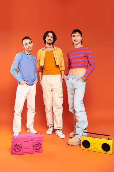 Drei positive attraktive schwule Freunde in lebhafter Kleidung posieren mit Tonbandgeräten, stolzer Monat — Stockfoto