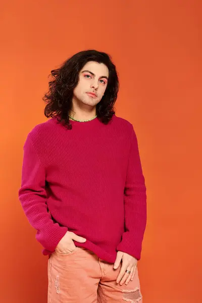 Trendy good looking gay man with long hair in magenta sweatshirt looking at camera, pride month — Stock Photo