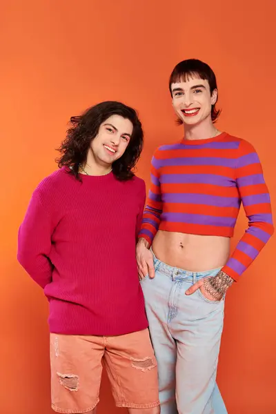 Good looking stylish jolly gay friends in vibrant clothes posing happily together, pride month — Stock Photo