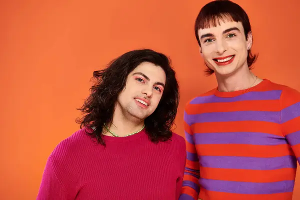 Handsome stylish jolly gay friends in vibrant clothes posing happily together, pride month — Stock Photo