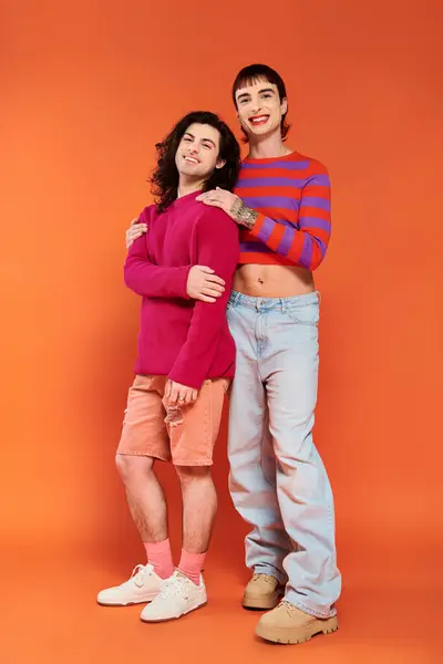 Привлекательные стильные весёлые друзья-геи в яркой одежде, счастливо позирующие вместе, месяц гордости — стоковое фото