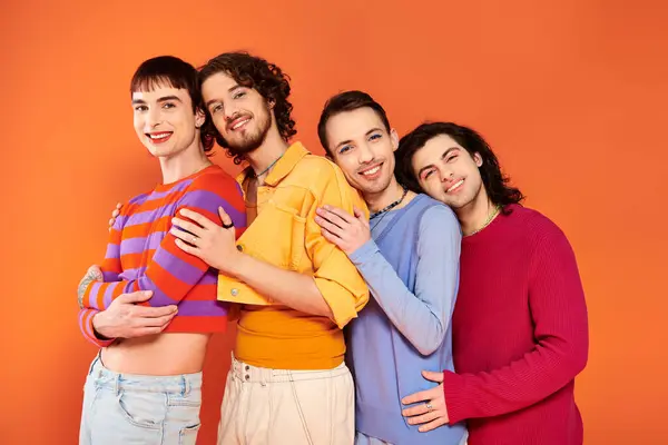 Cuatro modish atractivo alegre gay hombres en vibrante ropa posando juntos activamente, orgullo mes - foto de stock