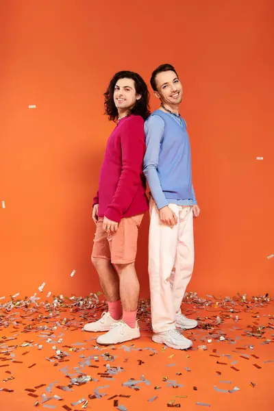 Fröhlich gut aussehende schwule Freunde in stilvoller Kleidung mit Make-up posieren unter Konfettiregen, Stolz — Stockfoto