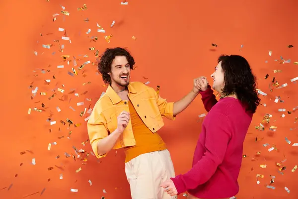 Joyous good looking gay friends in stylish clothes with makeup posing under confetti rain, pride — Stock Photo