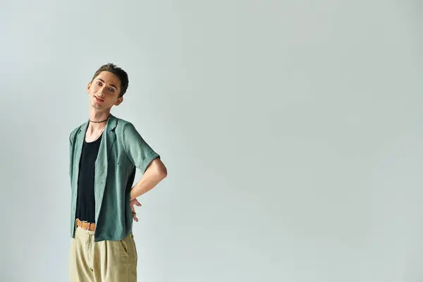 Una joven queer posando confiadamente sobre un trasfondo neutral. - foto de stock