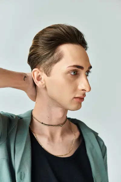 Un joven queer posa orgullosamente con un collar alrededor de su cuello en un ambiente de estudio, exudando confianza y orgullo. — Stock Photo