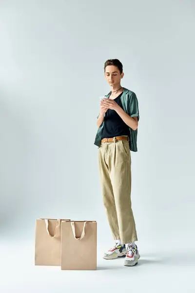 A stylish woman with shopping bags strikes a pose against a plain white background. — Stock Photo