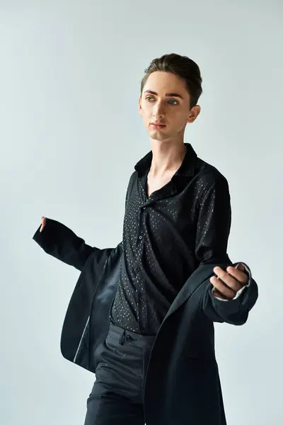 Молодой педик уверенно позирует в студии в черной куртке и рубашке, символизируя силу и гордость.. — стоковое фото