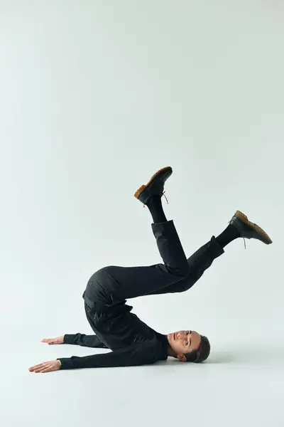 Una giovane persona queer mostra la sua forza ed equilibrio mentre esegue una postazione su uno sfondo bianco. — Foto stock