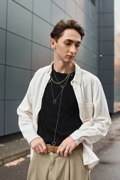 A stylish young individual in a white shirt and tan pants exudes confidence and pride. — Stock Photo