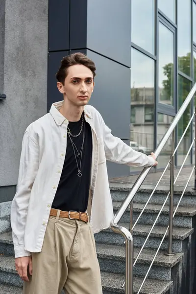 Um jovem indivíduo transpira confiança em uma camisa branca e calças cáqui, mostrando sua identidade gay com orgulho e estilo. — Fotografia de Stock