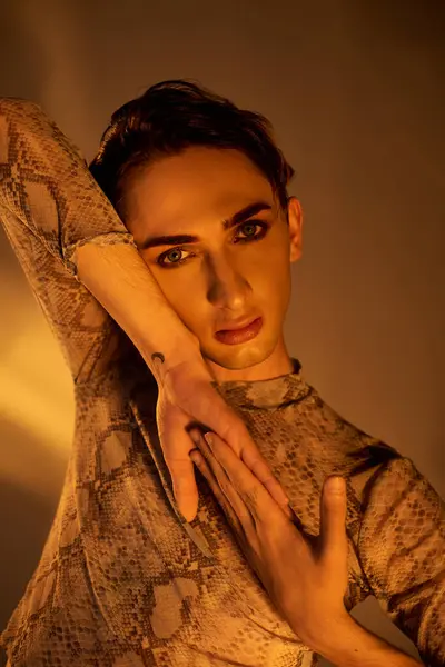 Una persona queer joven posa con confianza en un vestido de piel de pitón, encarnando estilo, identidad y orgullo. — Stock Photo