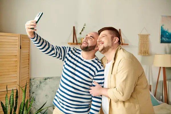 Two men pose for a selfie in a warm, inviting living room. — Stock Photo