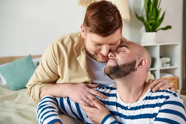 Un hombre besa calurosamente a otro hombre en la mejilla. - foto de stock