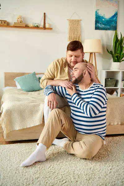 Two men, casually sitting on the floor, enjoying a moment together. — Stock Photo
