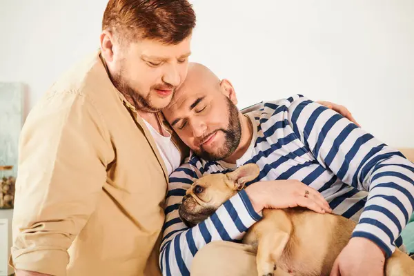 A man cradles a small French Bulldog in his arms, showing affection and care. — Stock Photo