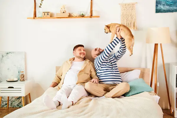 Un homme assis sur un lit avec un chien perché sur ses épaules. — Photo de stock