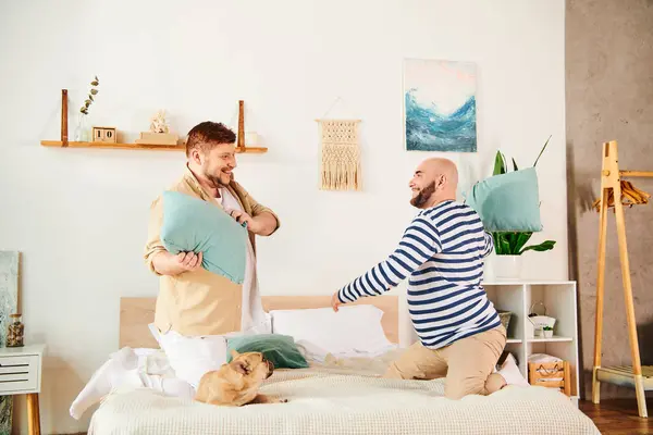 Gay couple and French bulldog on bed. — Stock Photo