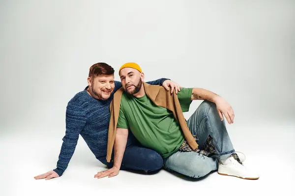 Dos hombres sentados en el suelo, posando para una foto. - foto de stock